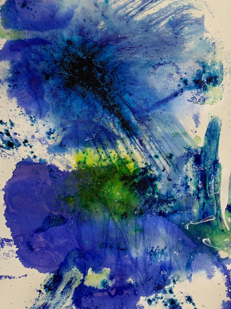 An abstract image of a bright blue paint splash on white paper.