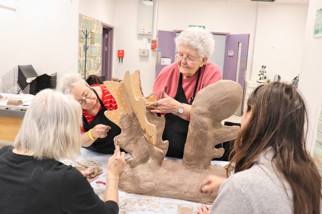 A photograph of a group from the retirement village building sculptures in a workshop