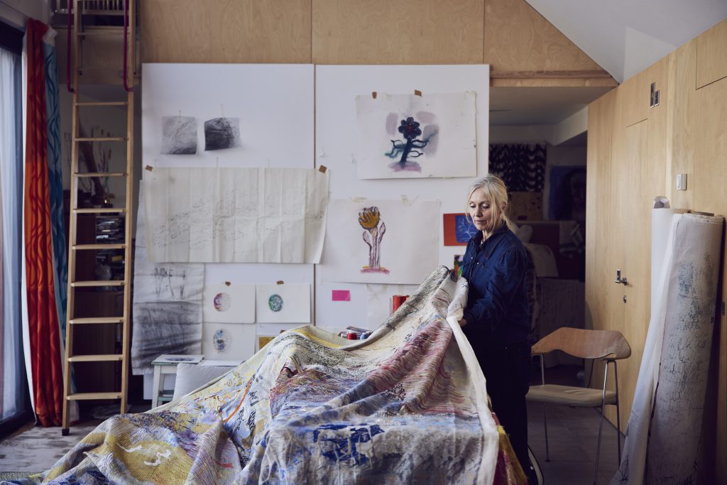 A colour photograph of artist Alice Kettle at work in her studio