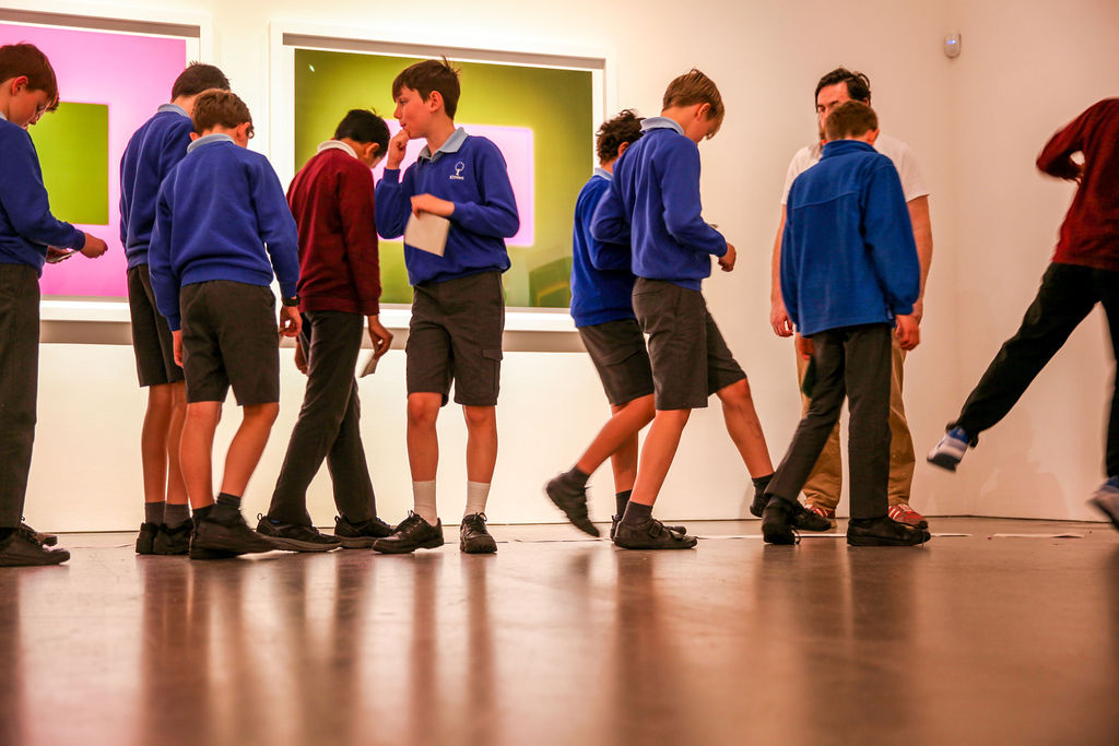 A coloured photograph of students walking around the galleries. 